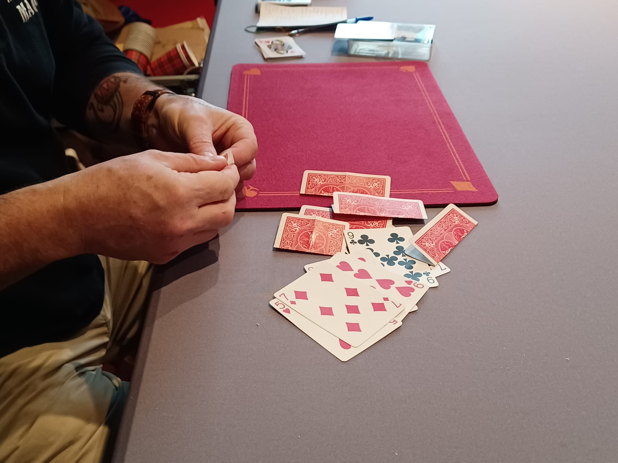 Mains de magicien et cartes sur un tapis de close-up