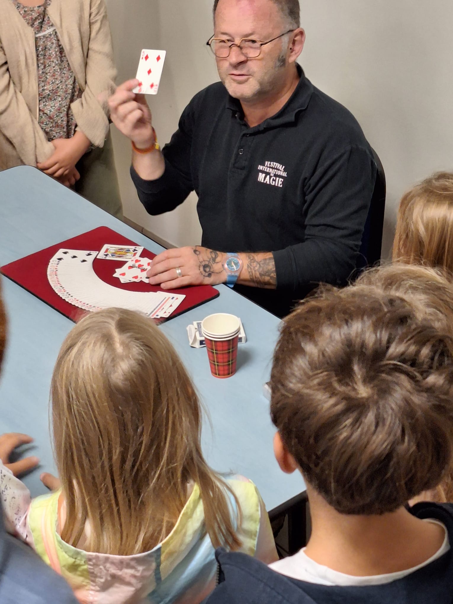 Strobineler montrant un tour de cartes aux enfants lors d’un atelier de magie