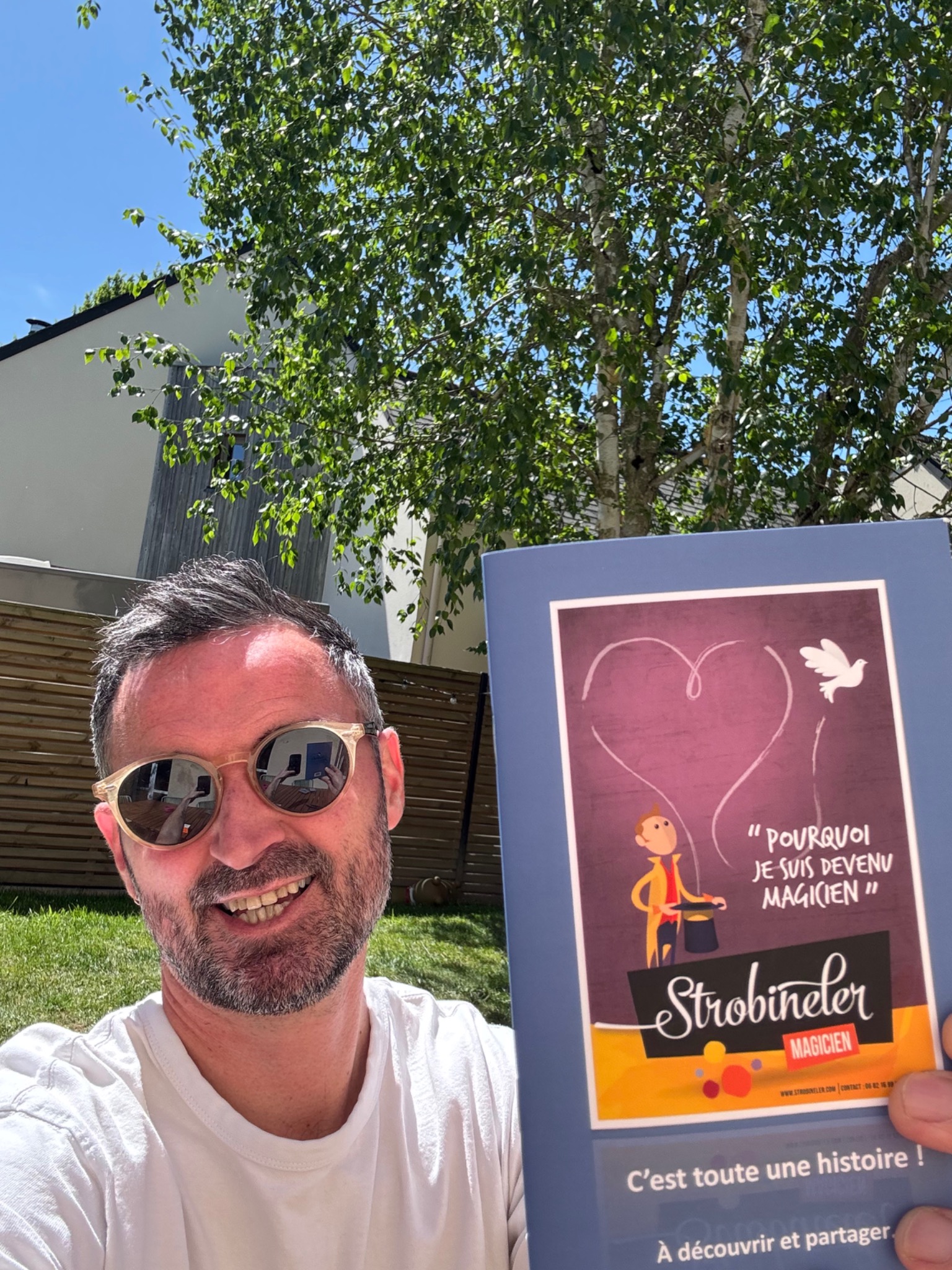Un lecteur présentant le livret sous le soleil
