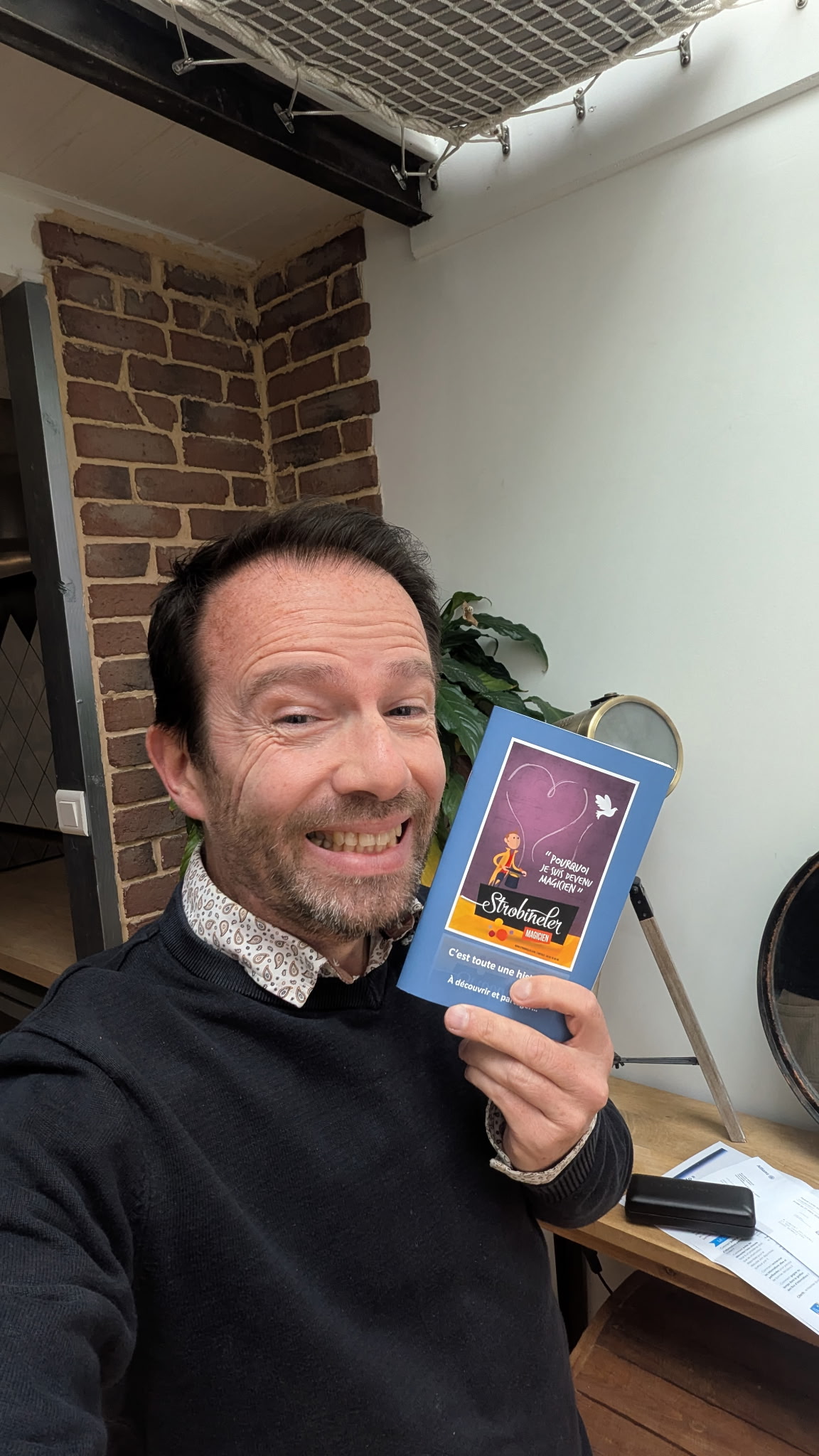 Un lecteur souriant avec le livret du spectacle