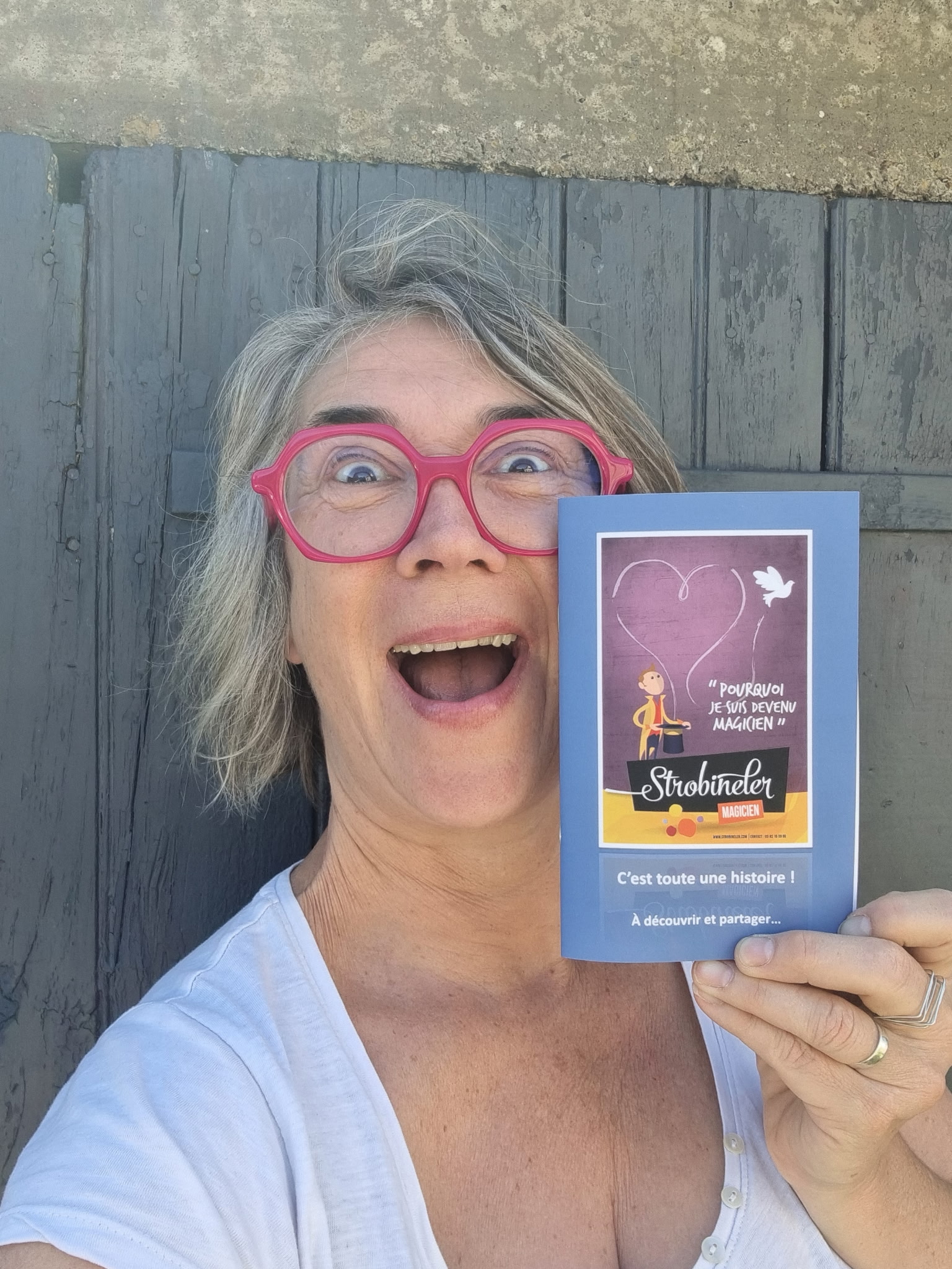 Une lectrice souriante présentant le livret du spectacle